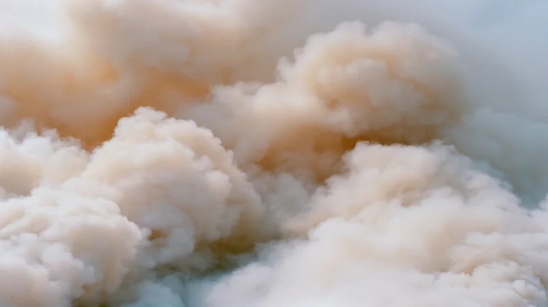 Thick white billowing smoke filling the frame with soft texture and warm light tones