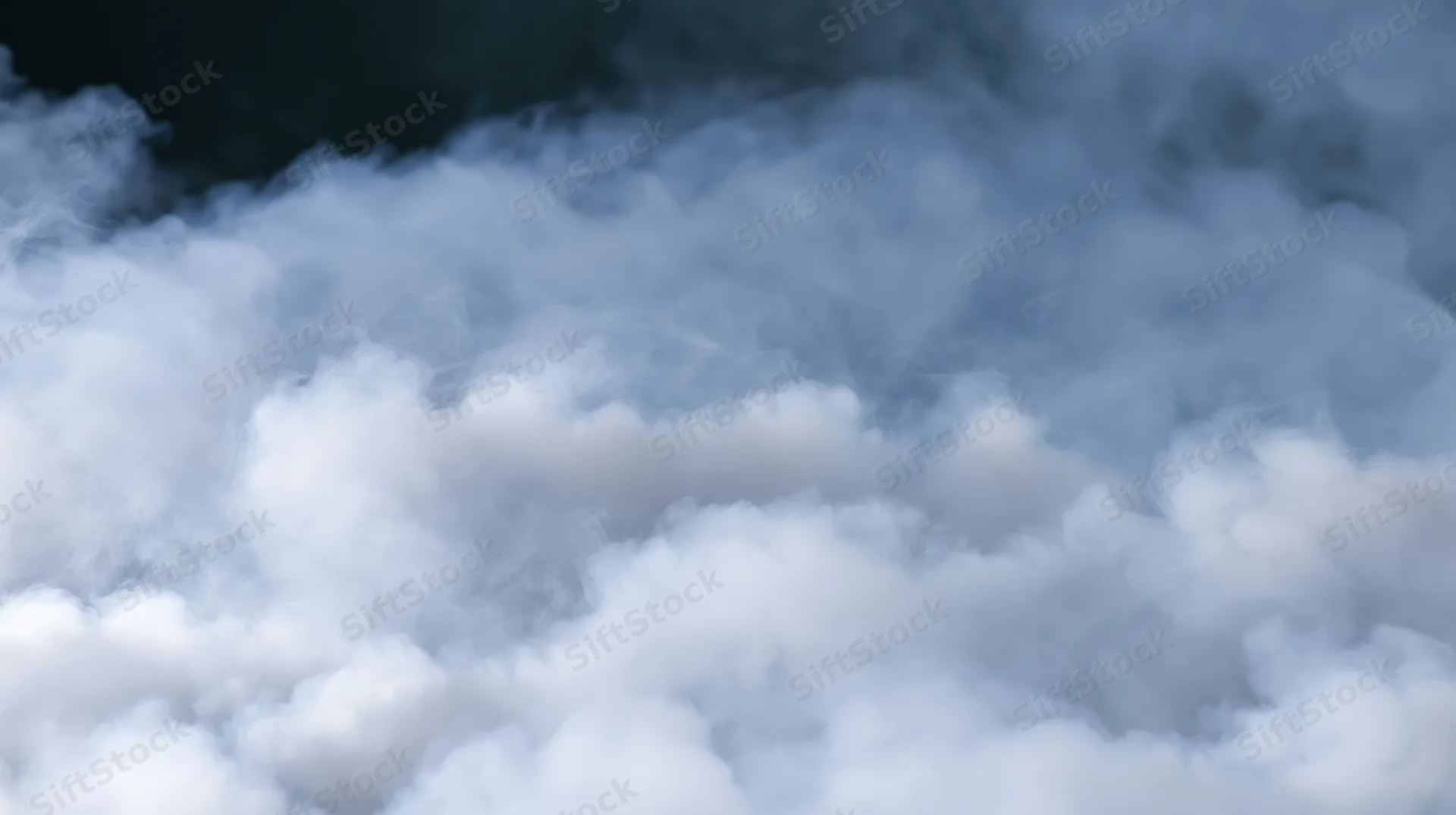 Dense white smoke billowing and rolling against a dark background