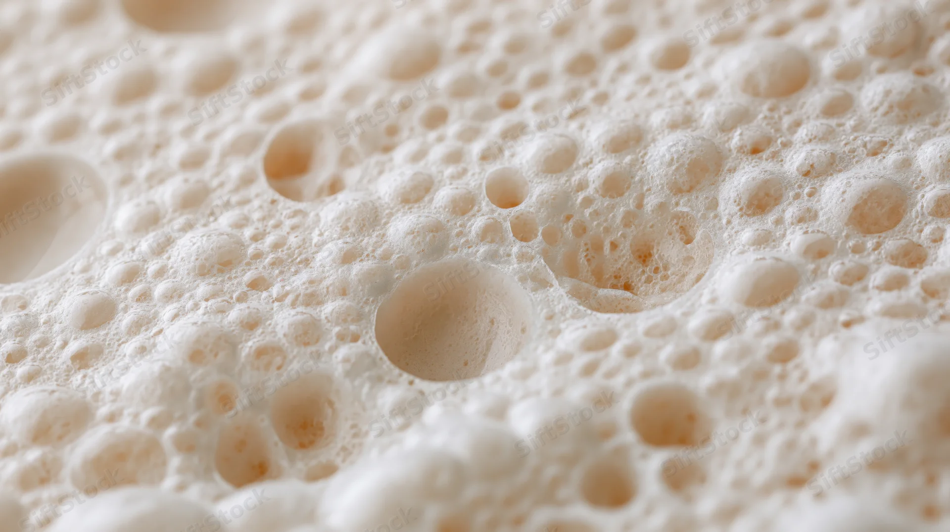 Close-up of milk foam surface with bubbles and froth