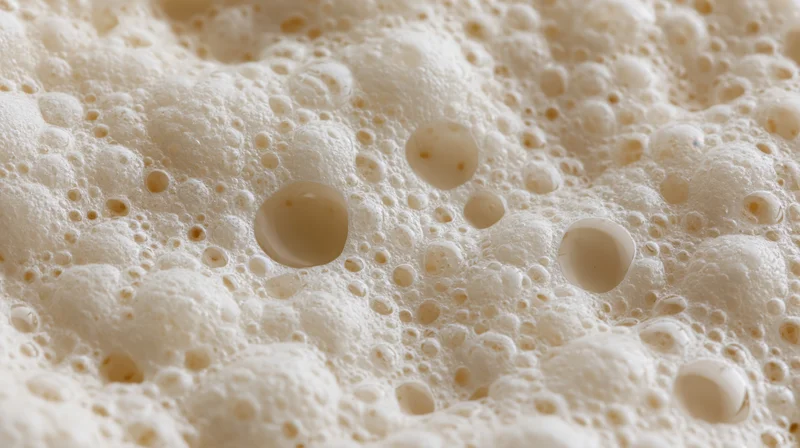 Close-up of milk foam surface with bubbles and creamy texture