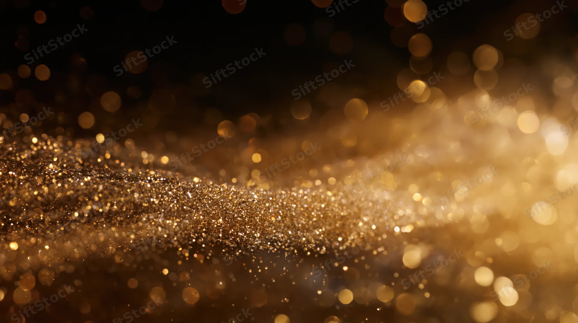Golden glitter particles shimmering in soft focus against dark background