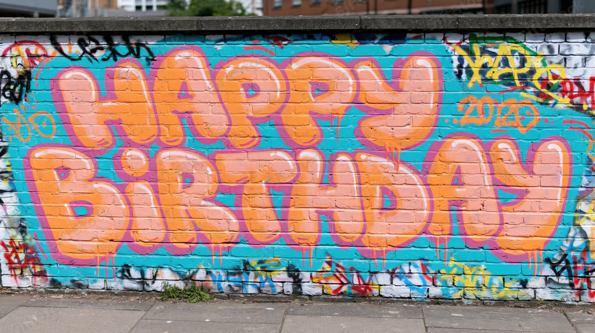 Happy birthday graffiti lettering spray-painted on a brick wall in an urban setting