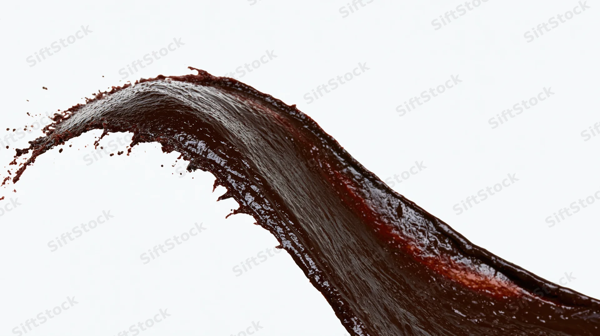 Dark chocolate liquid splashing in dynamic arc against white background