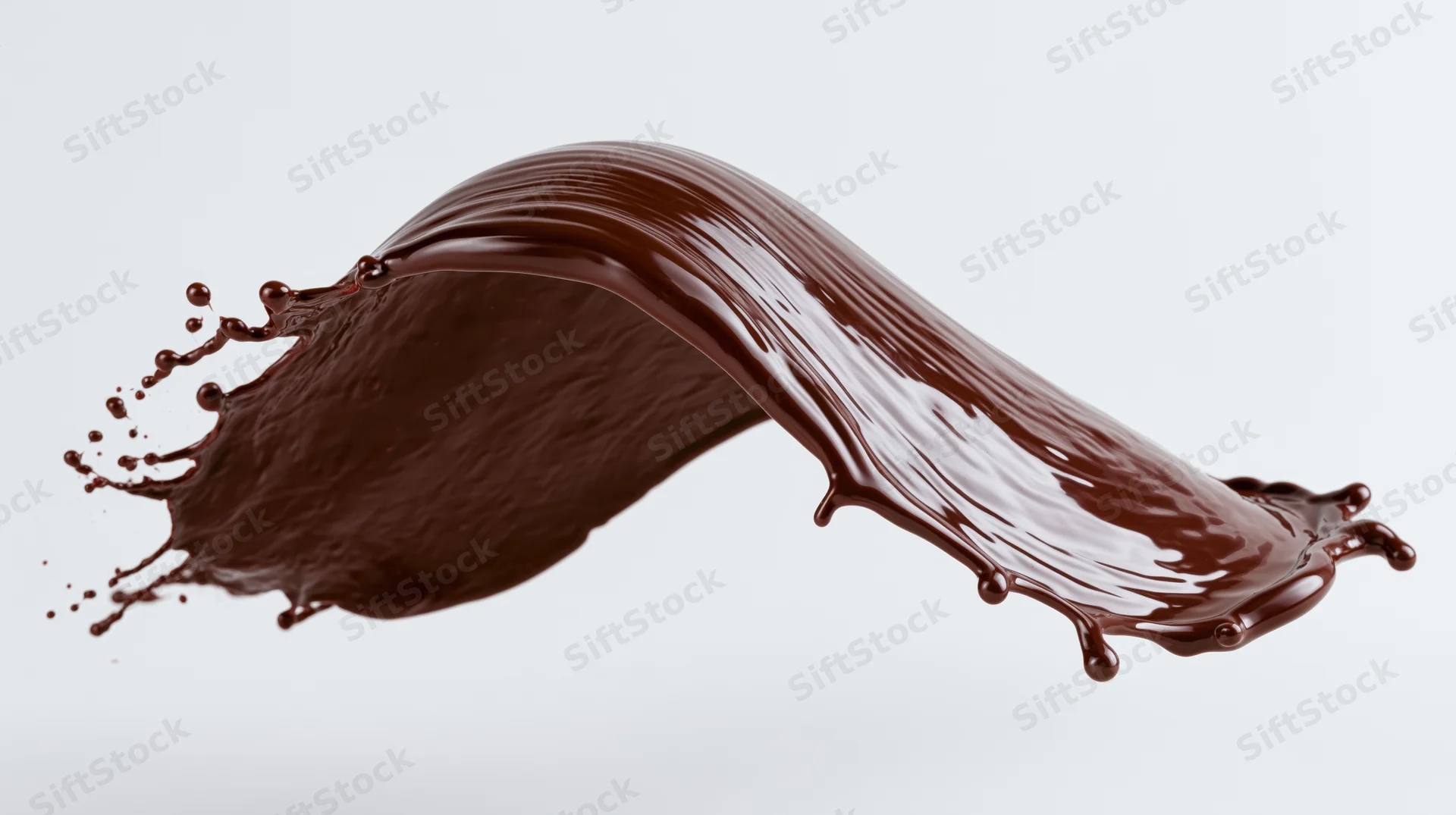 Dark chocolate liquid splashing in mid-air frozen in motion against white background