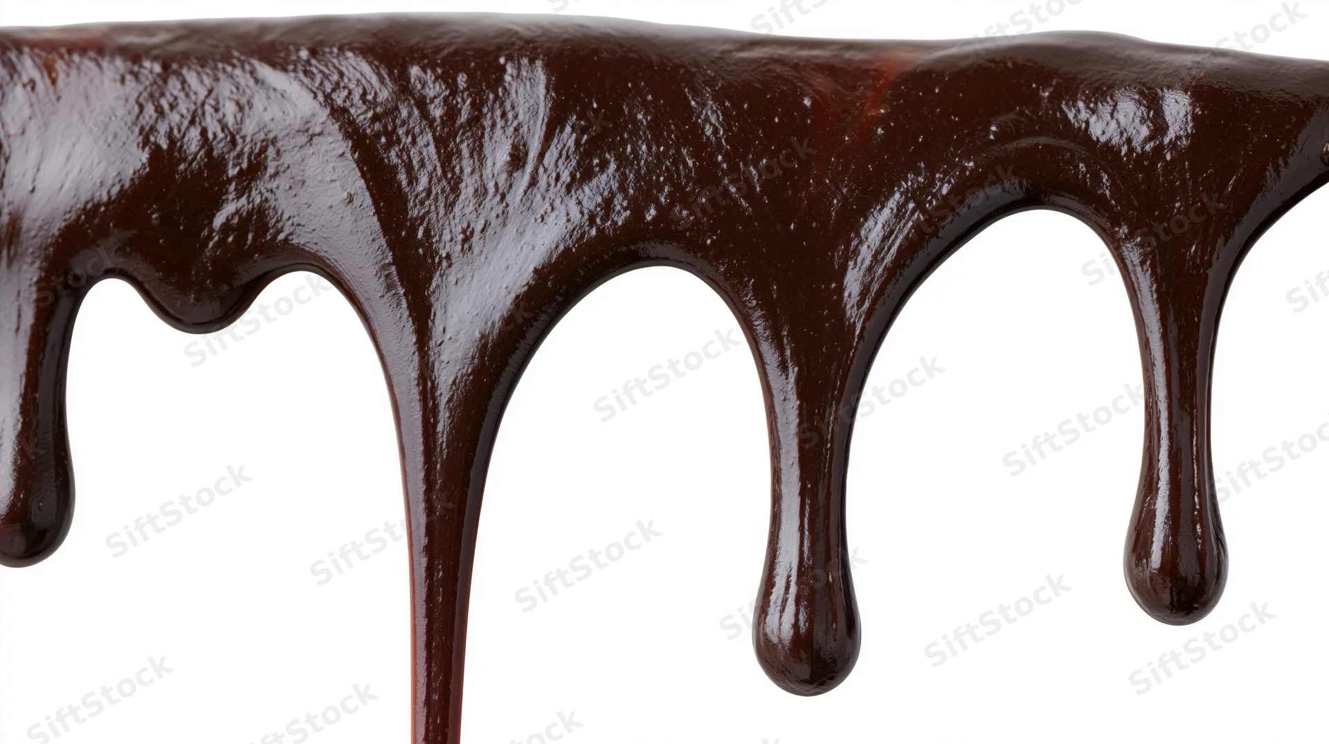 Melted dark chocolate dripping downward in slow flowing streams on white background