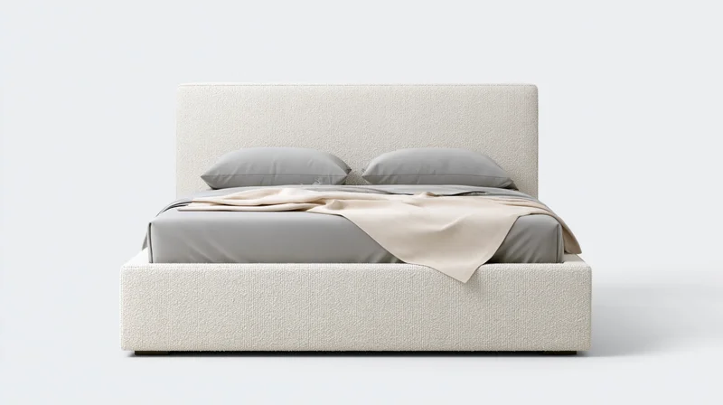 Modern upholstered platform bed with gray bedding and beige throw blanket, photographed straight-on against white background