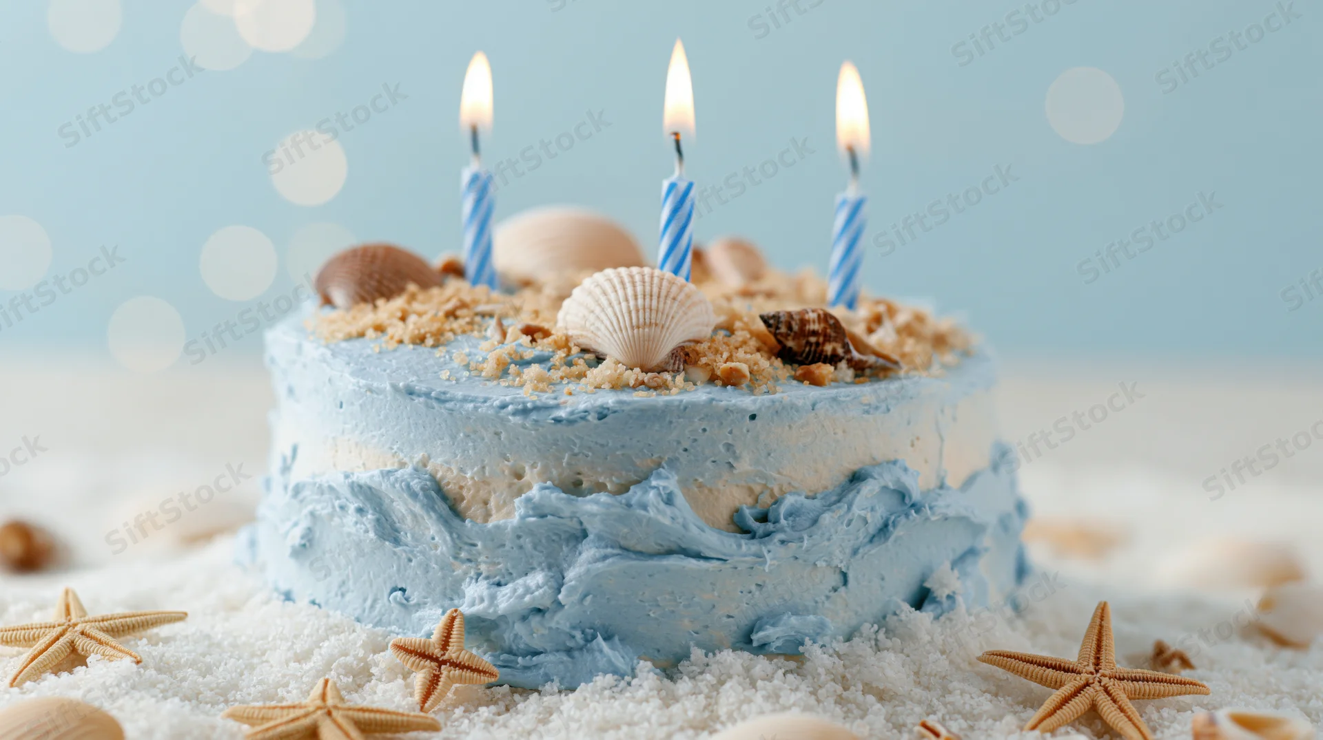 Ocean-themed birthday cake with blue frosting, seashells and starfish on sand, lit candles on top