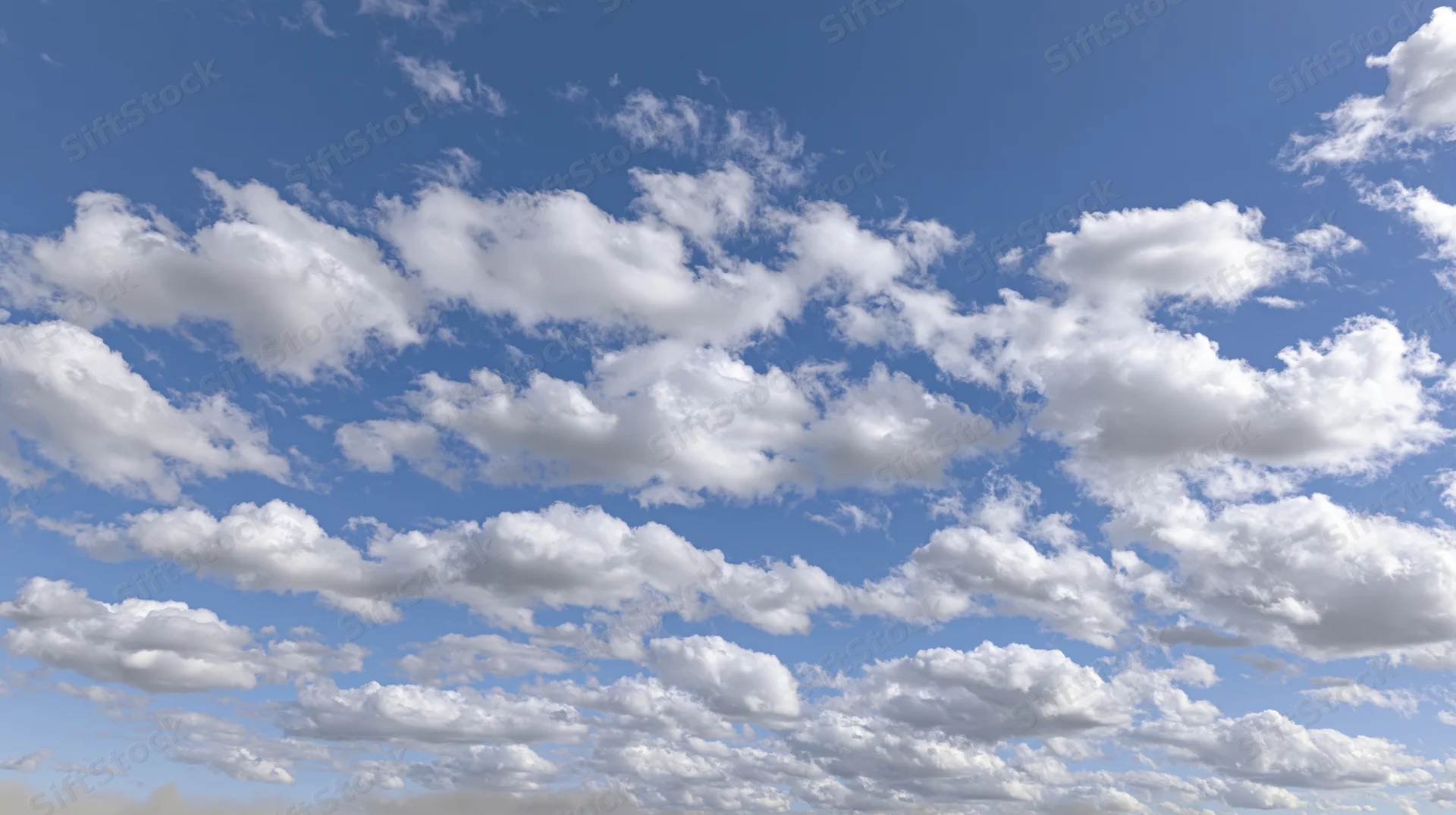 Open sky with scattered cumulus clouds drifting across a bright blue expanse