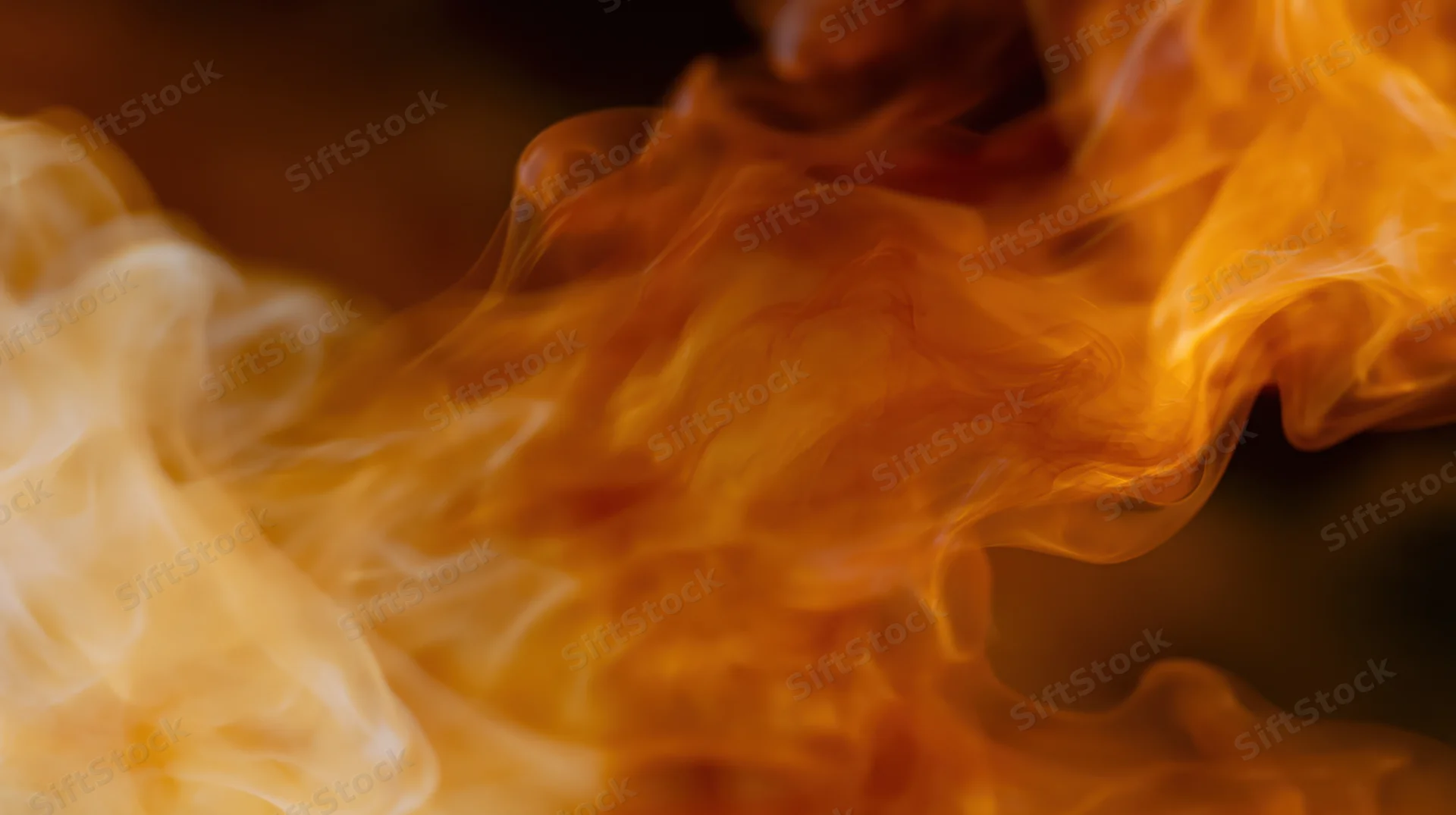 Swirling orange and amber smoke wisps rising in a dynamic closeup