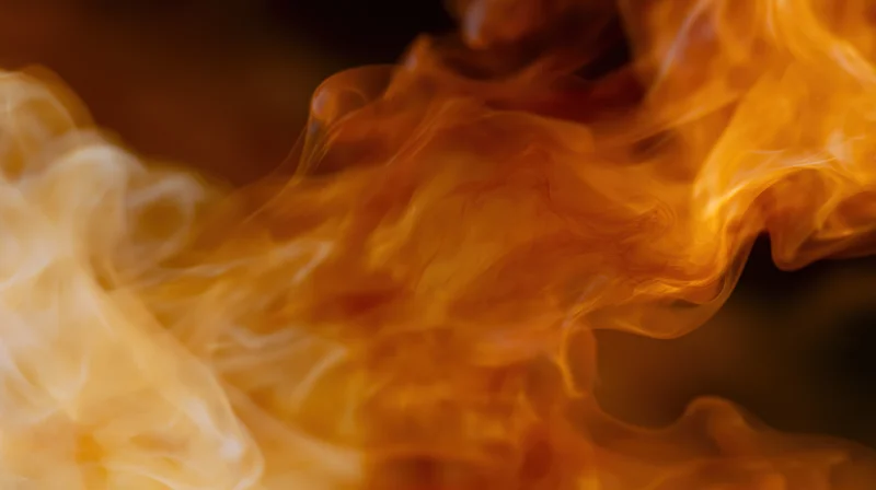 Swirling orange and amber smoke wisps rising in a dynamic closeup