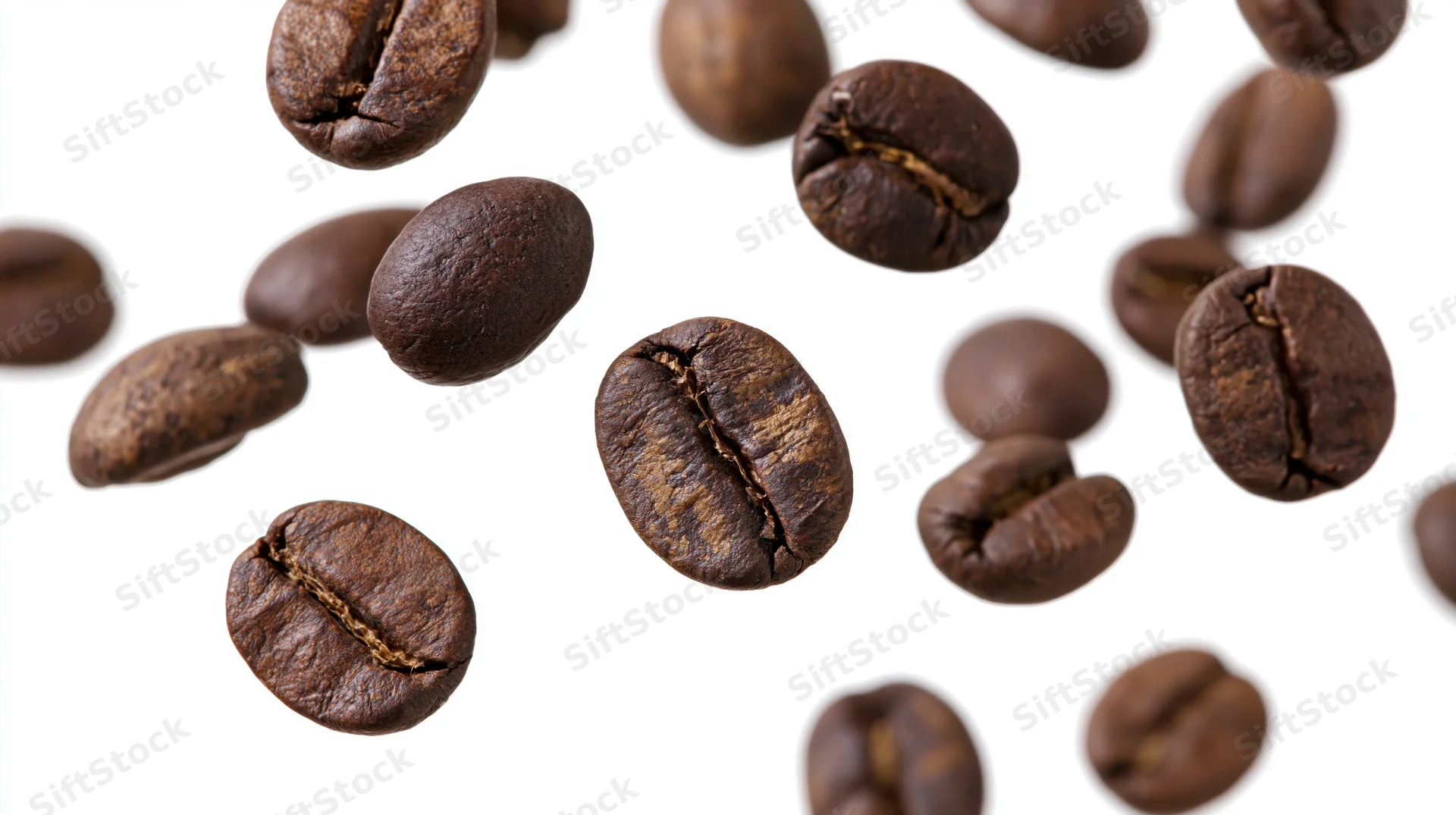 Roasted coffee beans floating midair scattered against white background