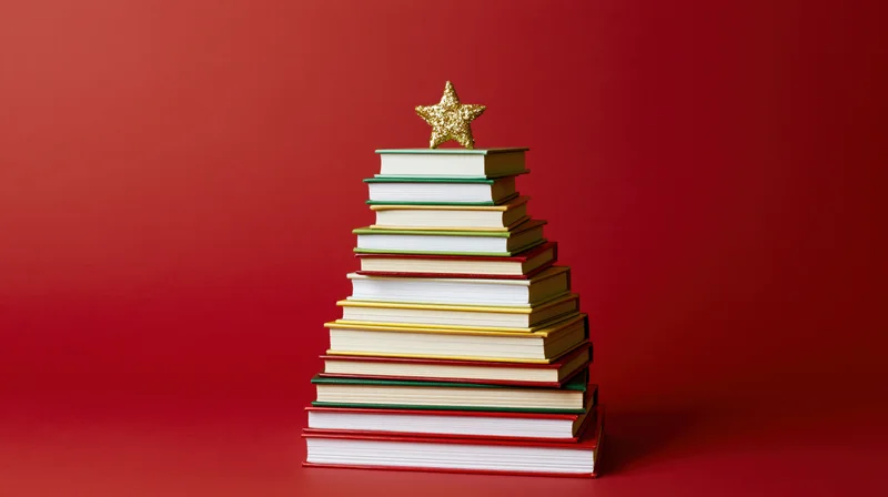 Stack of colorful hardcover books arranged in triangular shape with golden star on top against red background