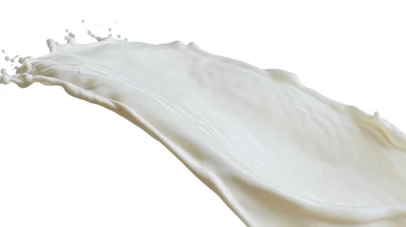 White milk splash frozen midair in a curved wave form against plain white background