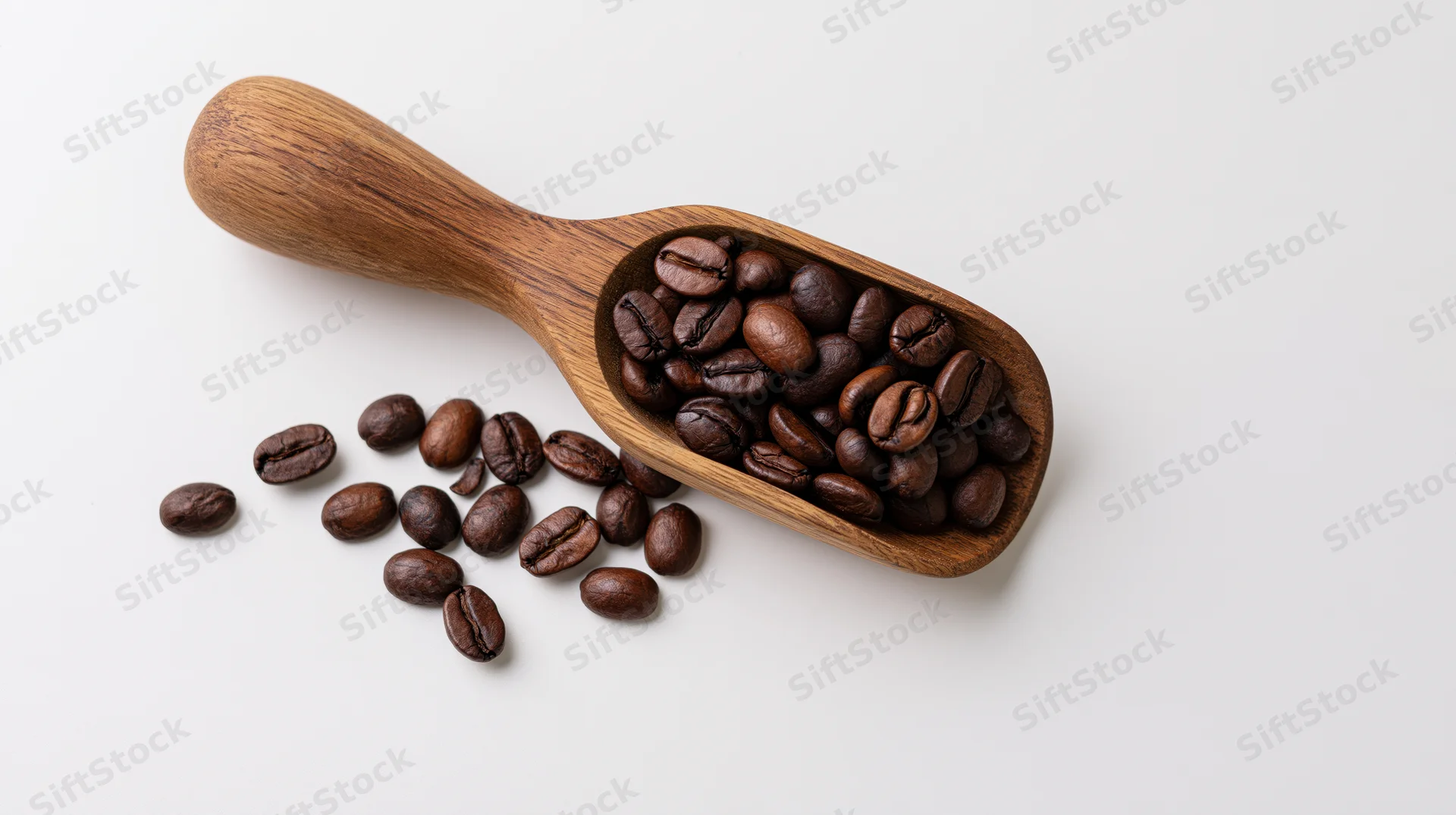 Wooden scoop filled with roasted coffee beans on white surface