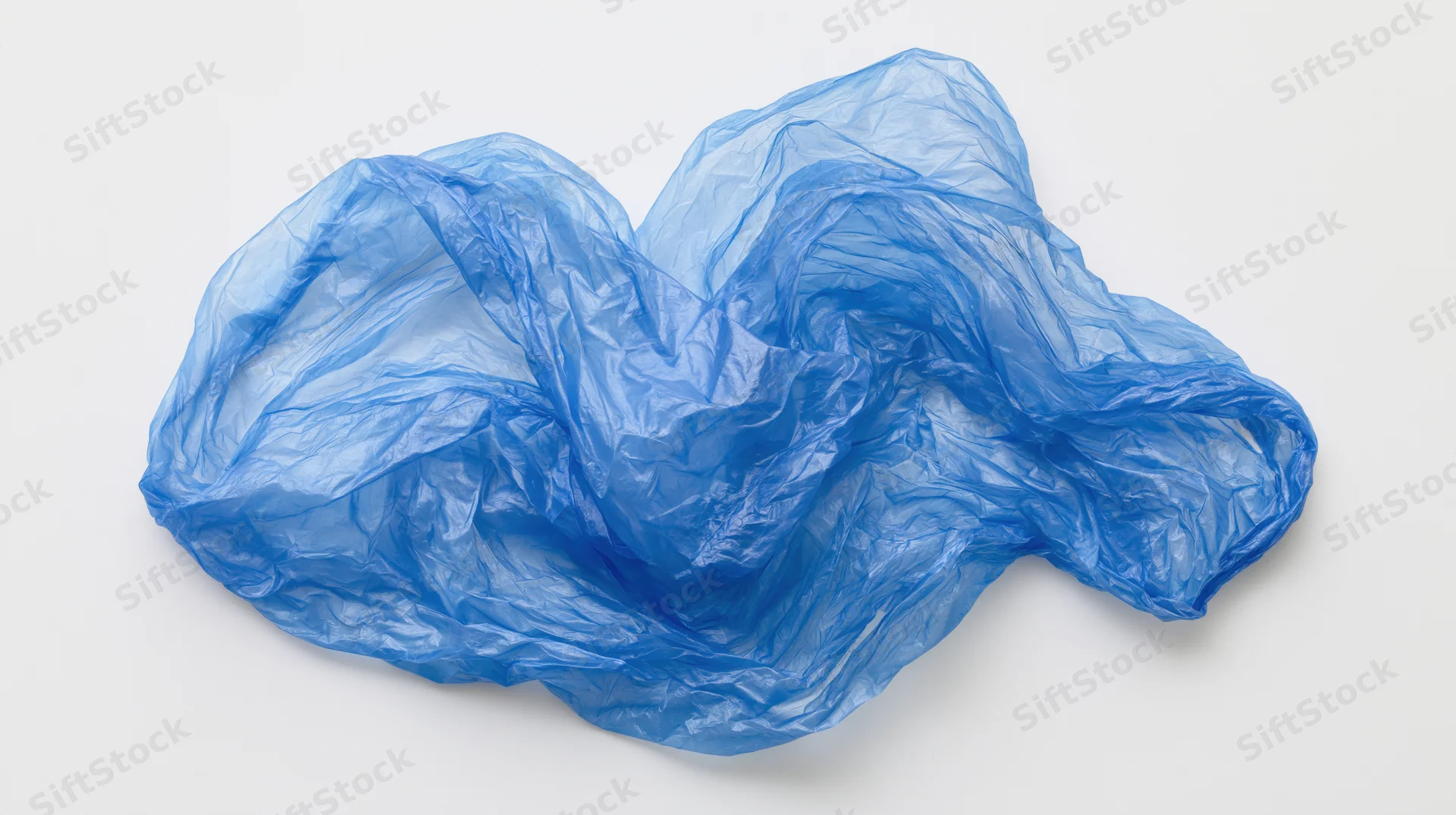Crumpled blue plastic bag lying flat on white surface