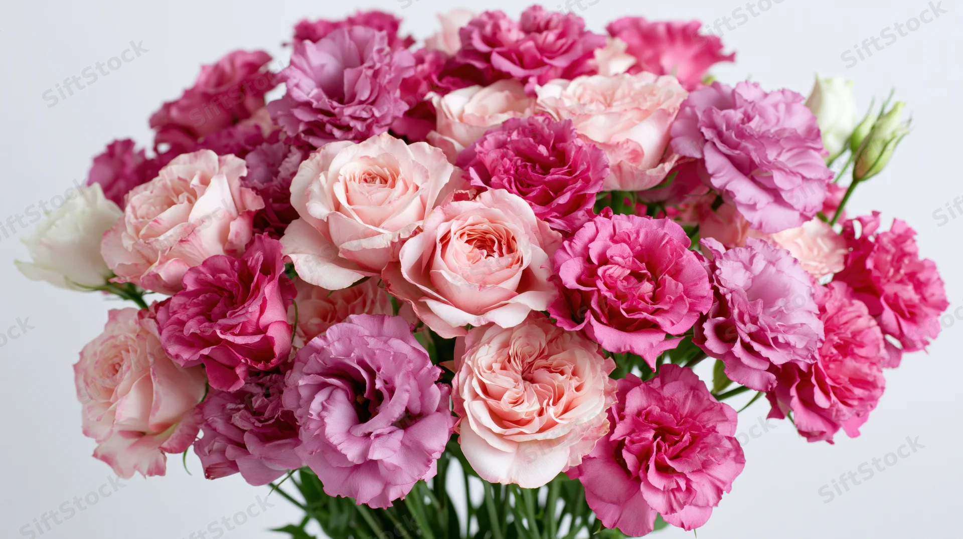 Dense bouquet of pink roses and lisianthus flowers arranged together against a white background