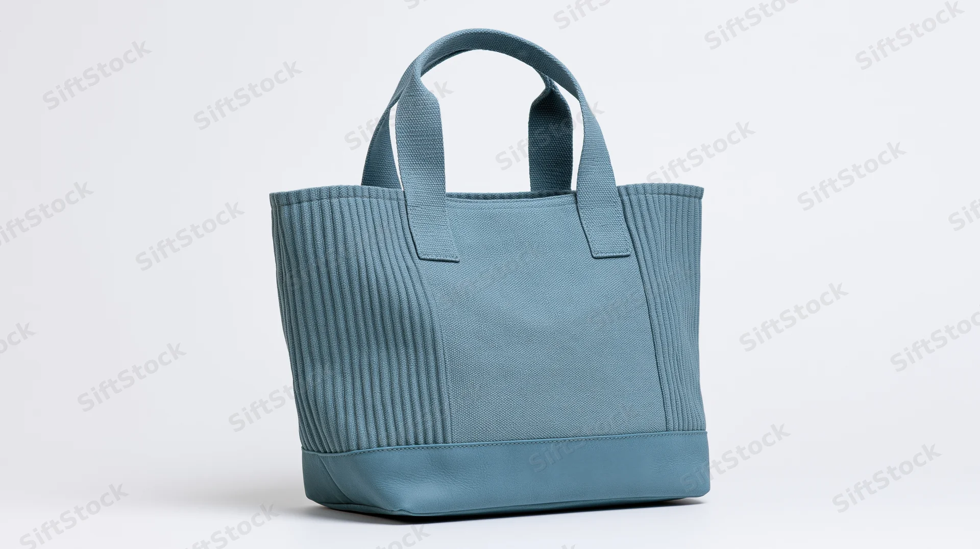Dusty blue canvas tote bag with ribbed texture standing on white background