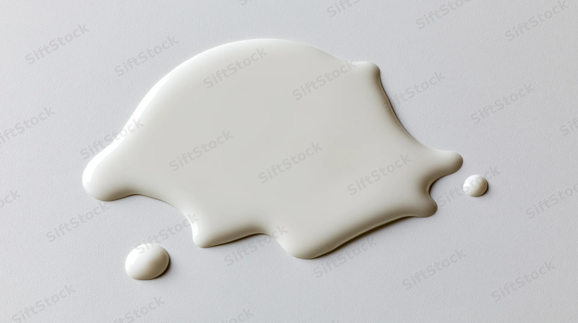 Spilled milk forming a puddle on a smooth white surface