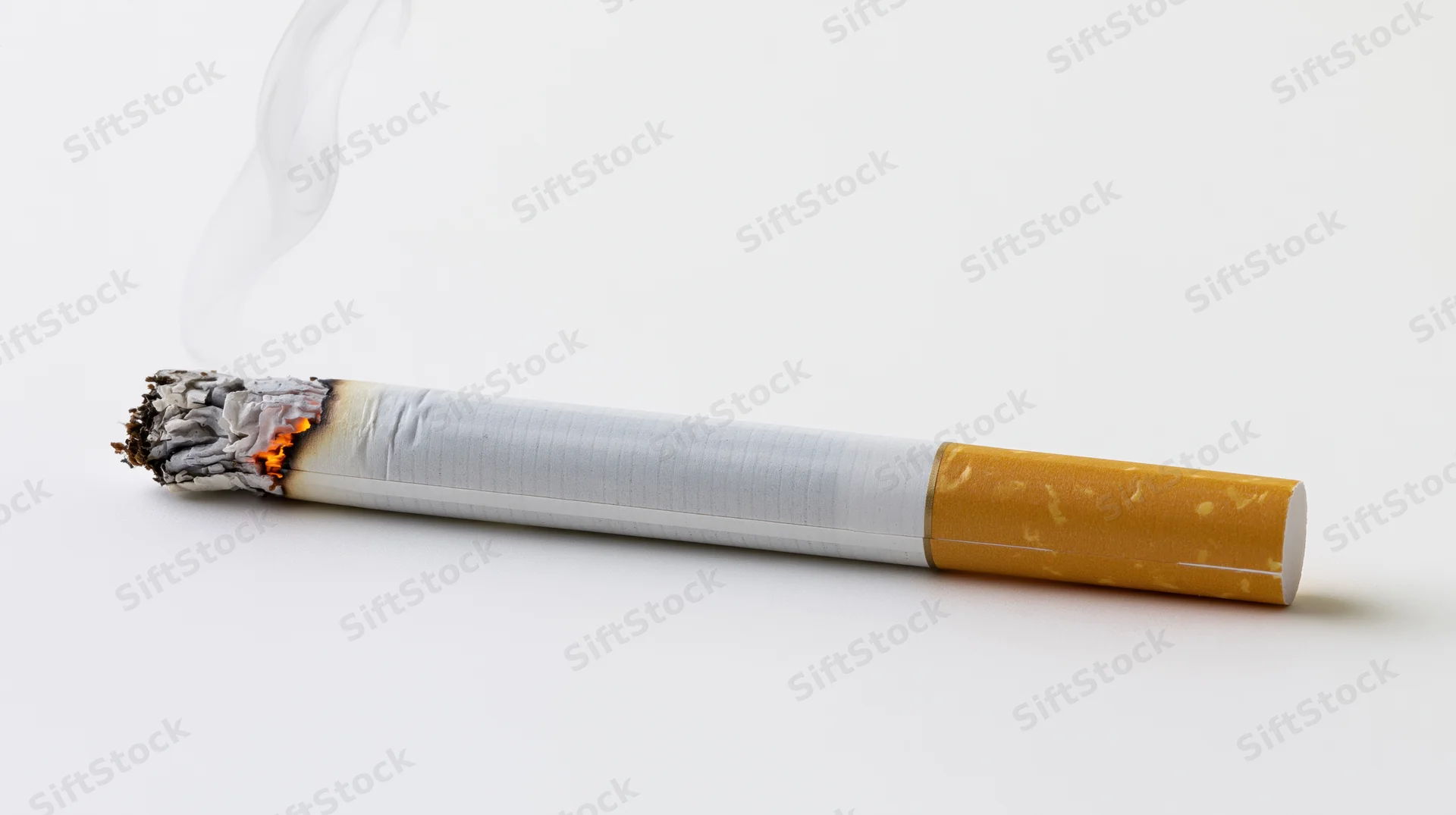 Lit cigarette burning horizontally on white surface with smoke rising from tip