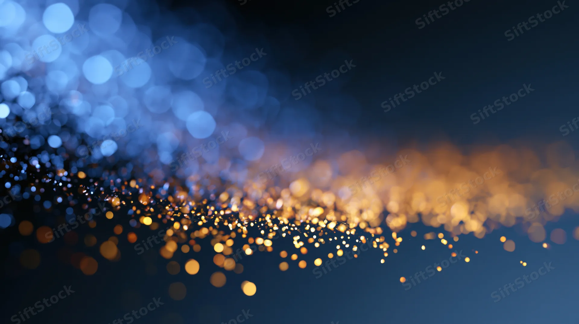 Abstract bokeh background with scattered out-of-focus golden and blue lights on dark surface