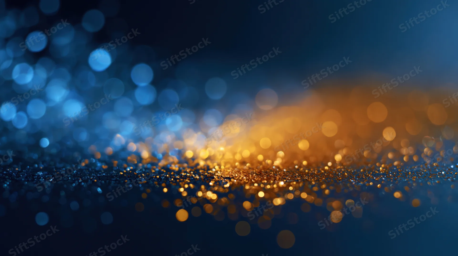Abstract bokeh background with scattered out-of-focus golden and blue lights on dark surface