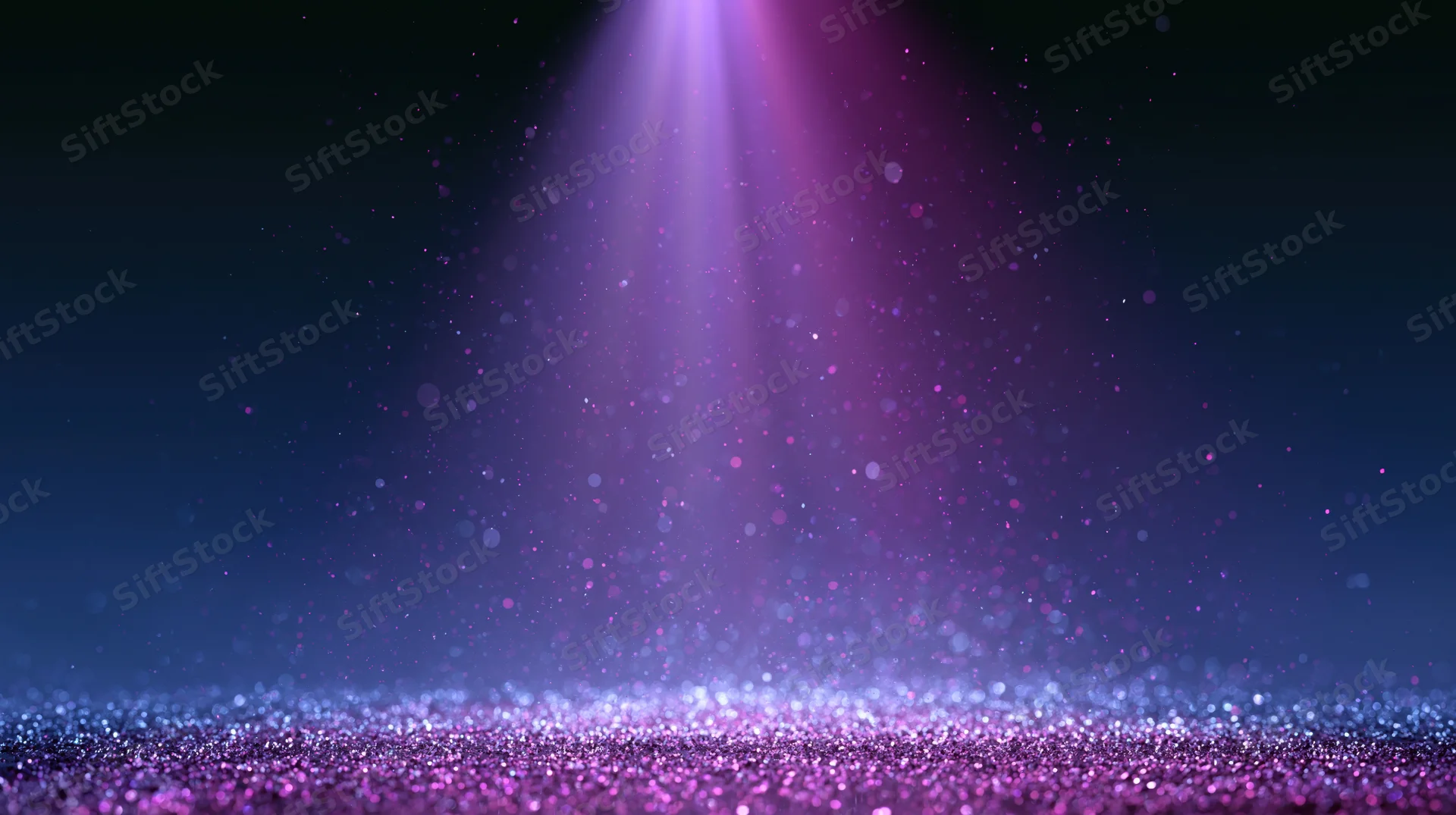 Purple spotlight shining down on glittering stage floor with floating particles in dark space