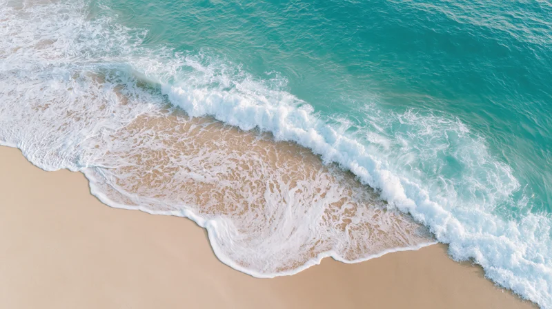 Waves breaking on a sandy beach from an aerial view