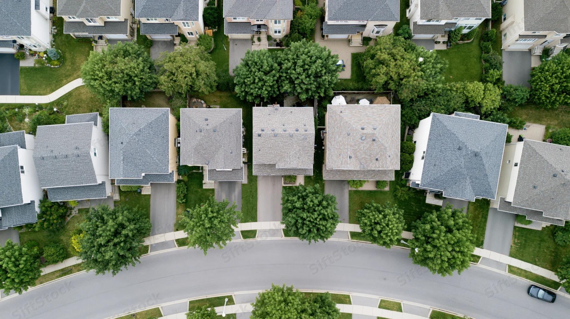 Aerial drone view looking straight down at suburban neighborhood with houses, trees, and curved street