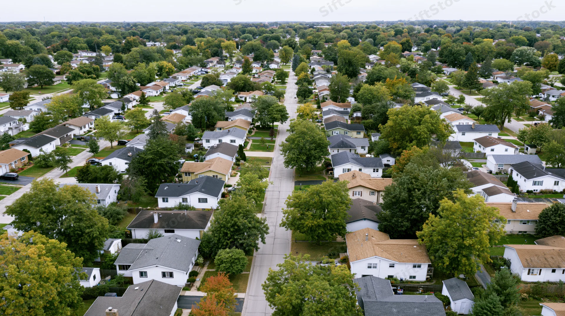 Aerial drone view looking straight down over a quiet midwest suburban neighborhood with houses, trees, and streets