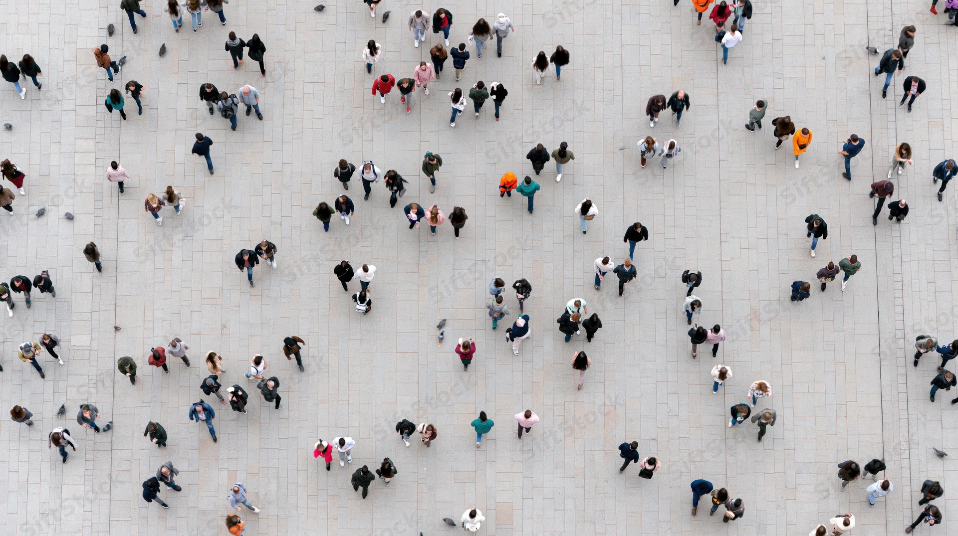 Aerial view of a large crowd of people walking on a stone plaza