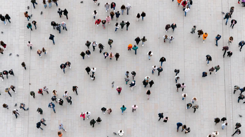 Aerial view of a large crowd of people walking on a stone plaza