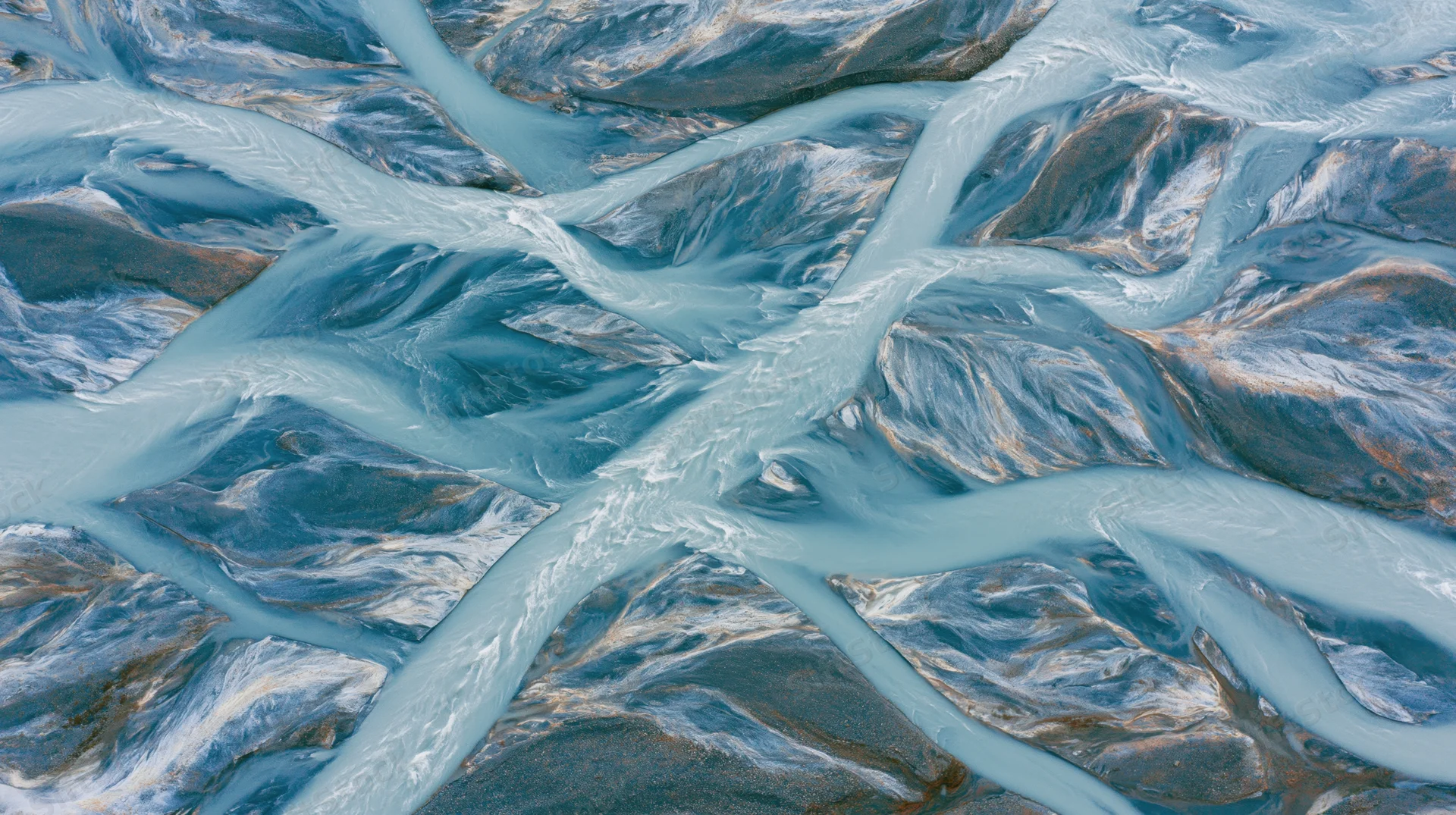Aerial view of a braided glacial river delta flowing over rocky terrain