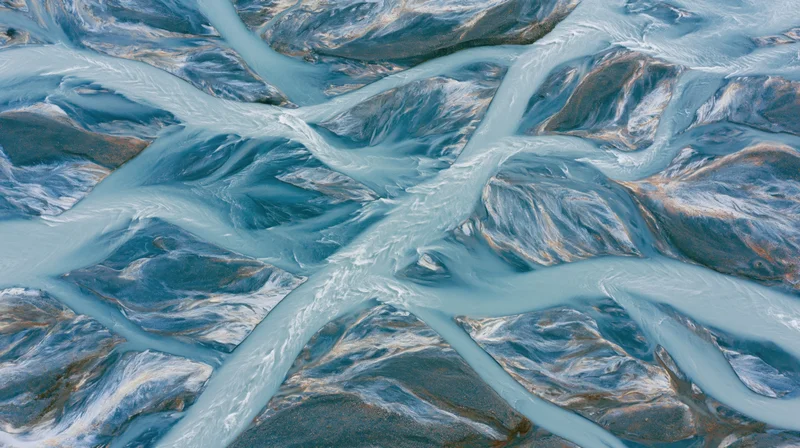 Aerial view of a braided glacial river delta flowing over rocky terrain