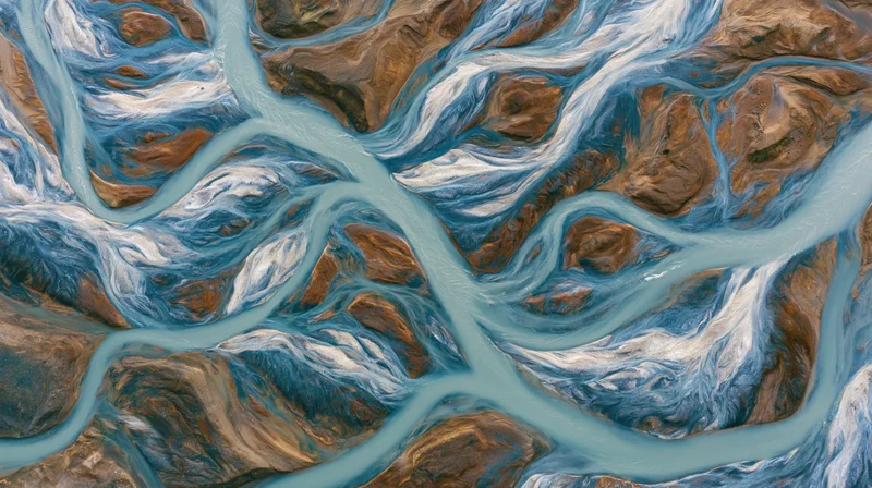 Aerial topdown view of a braided glacial river delta with multiple channels flowing through rocky terrain