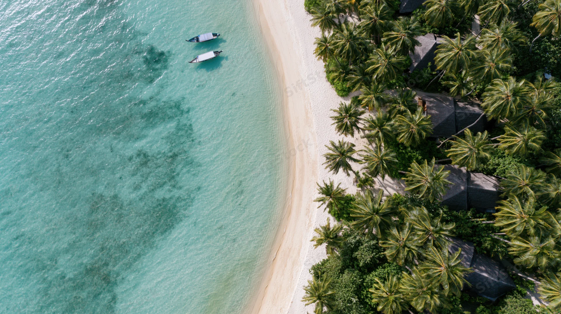 Aerial top-down view of a tropical beach resort with white sand, turquoise water, palm trees, and thatched-roof villas