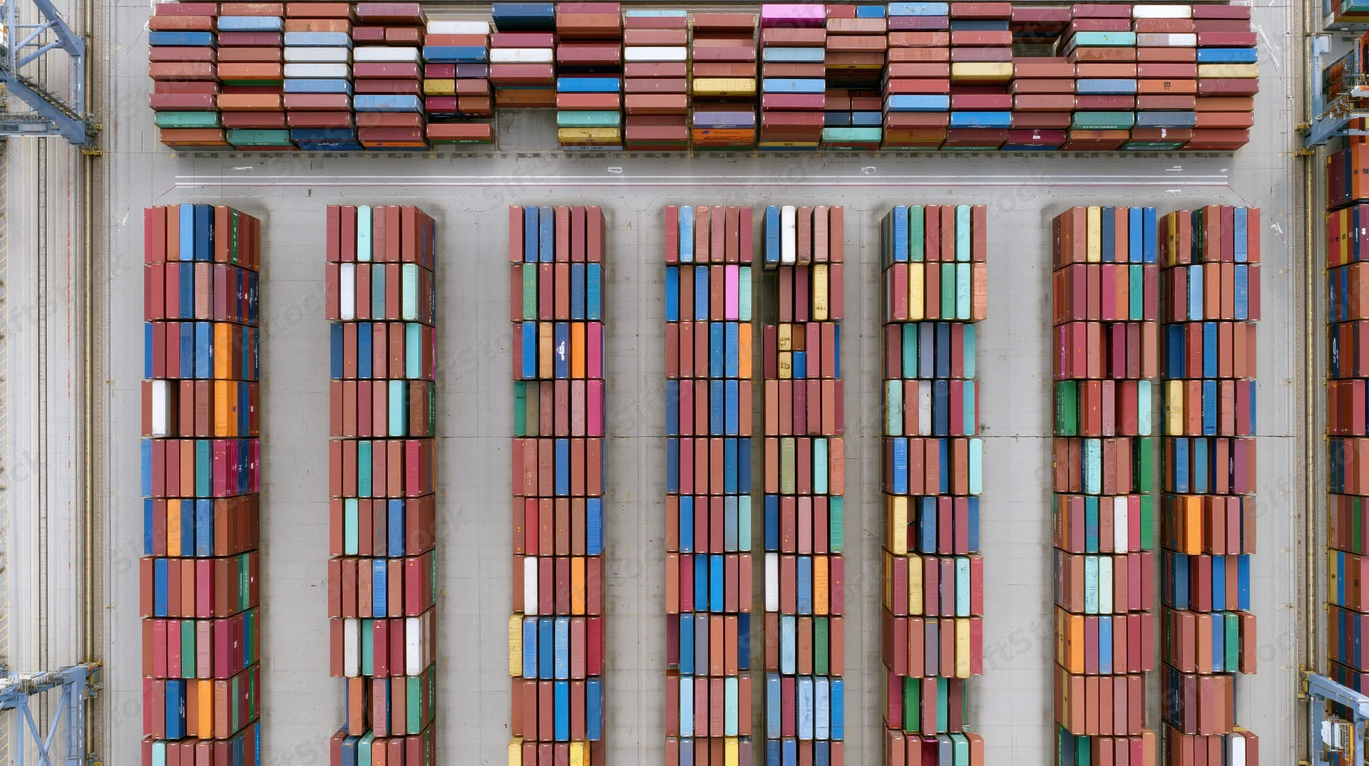 Aerial top-down view of stacked shipping containers in a commercial port terminal