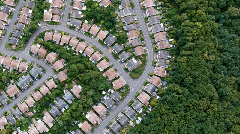 Aerial top-down view of a dense british residential suburb with winding streets and greenery