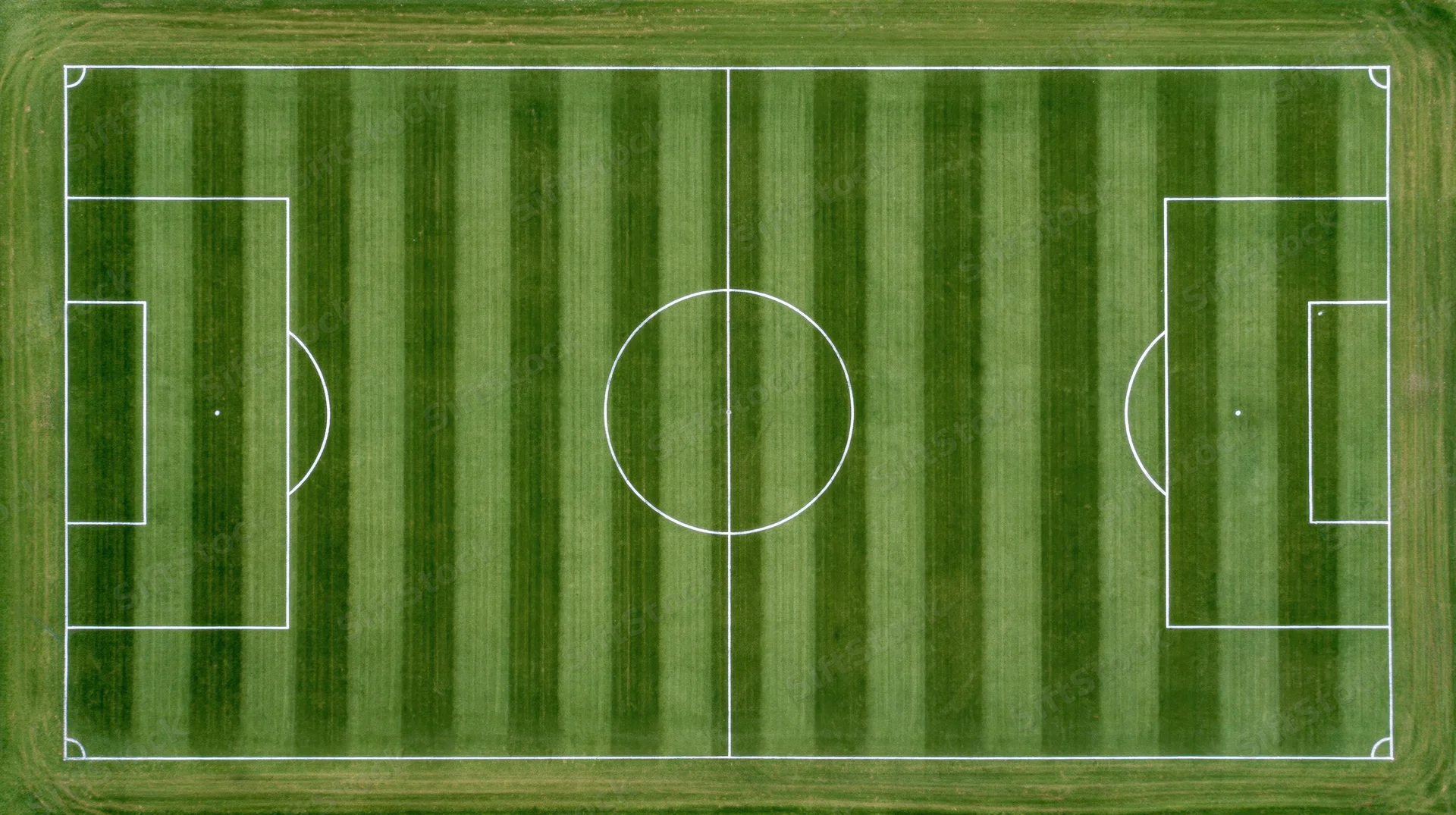 Aerial top-down view of a full soccer field with white painted lines on striped green grass