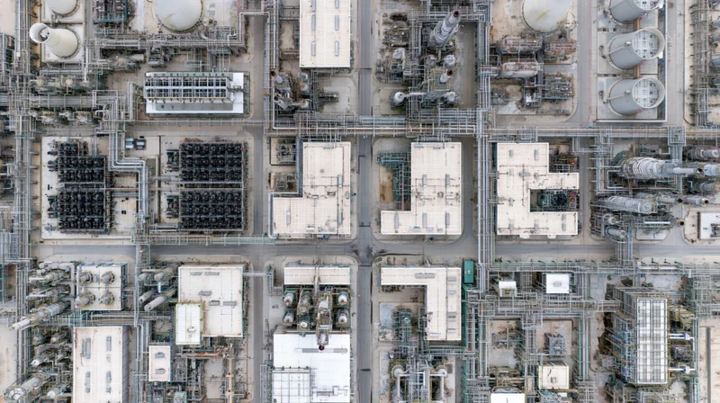 Aerial top-down view of a large petrochemical plant with interconnected tanks, pipelines and processing units