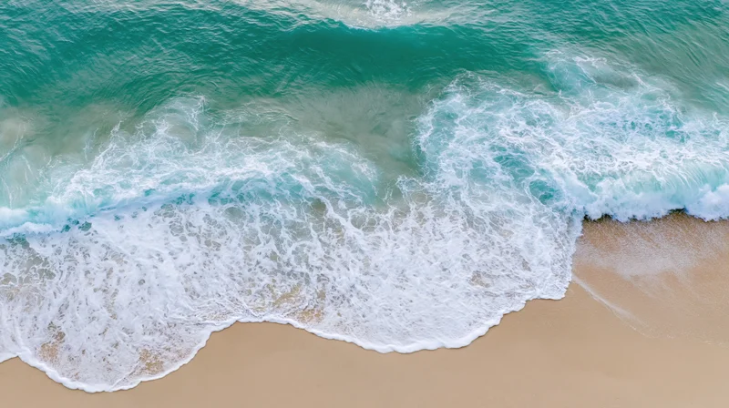 Ocean Wave Crest Rolling onto Golden Sandy Beach from Turquo