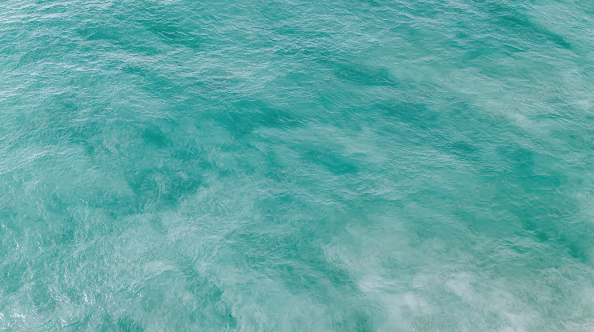 Aerial top-down view of open ocean surface with gentle ripple