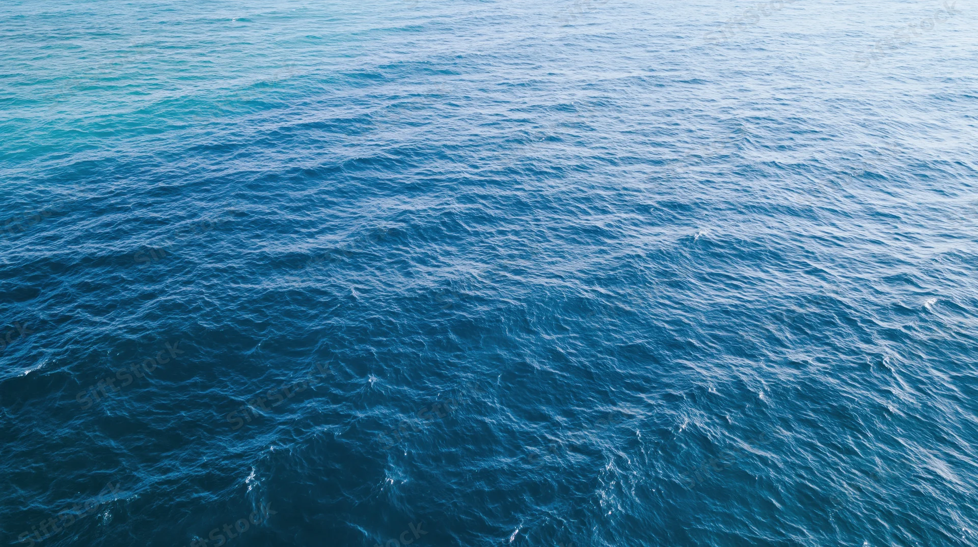 Aerial top-down view of open ocean surface with gentle ripples