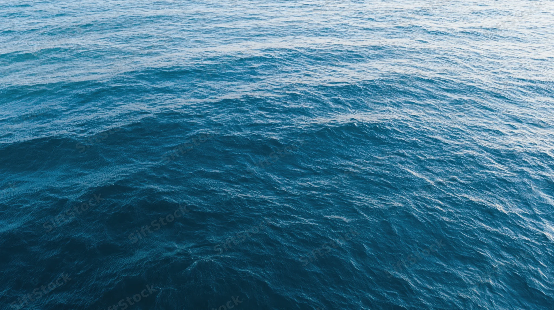 Aerial top-down view of open ocean surface with gentle ripple