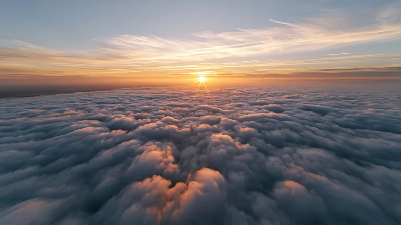 Aerial view above a dense sea of clouds at sunset