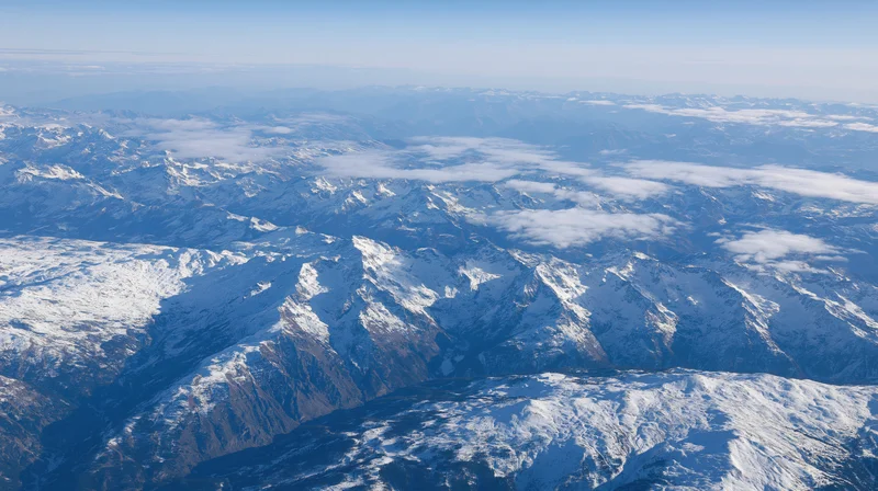 Aerial view of snow-covered mountain range under clear sky