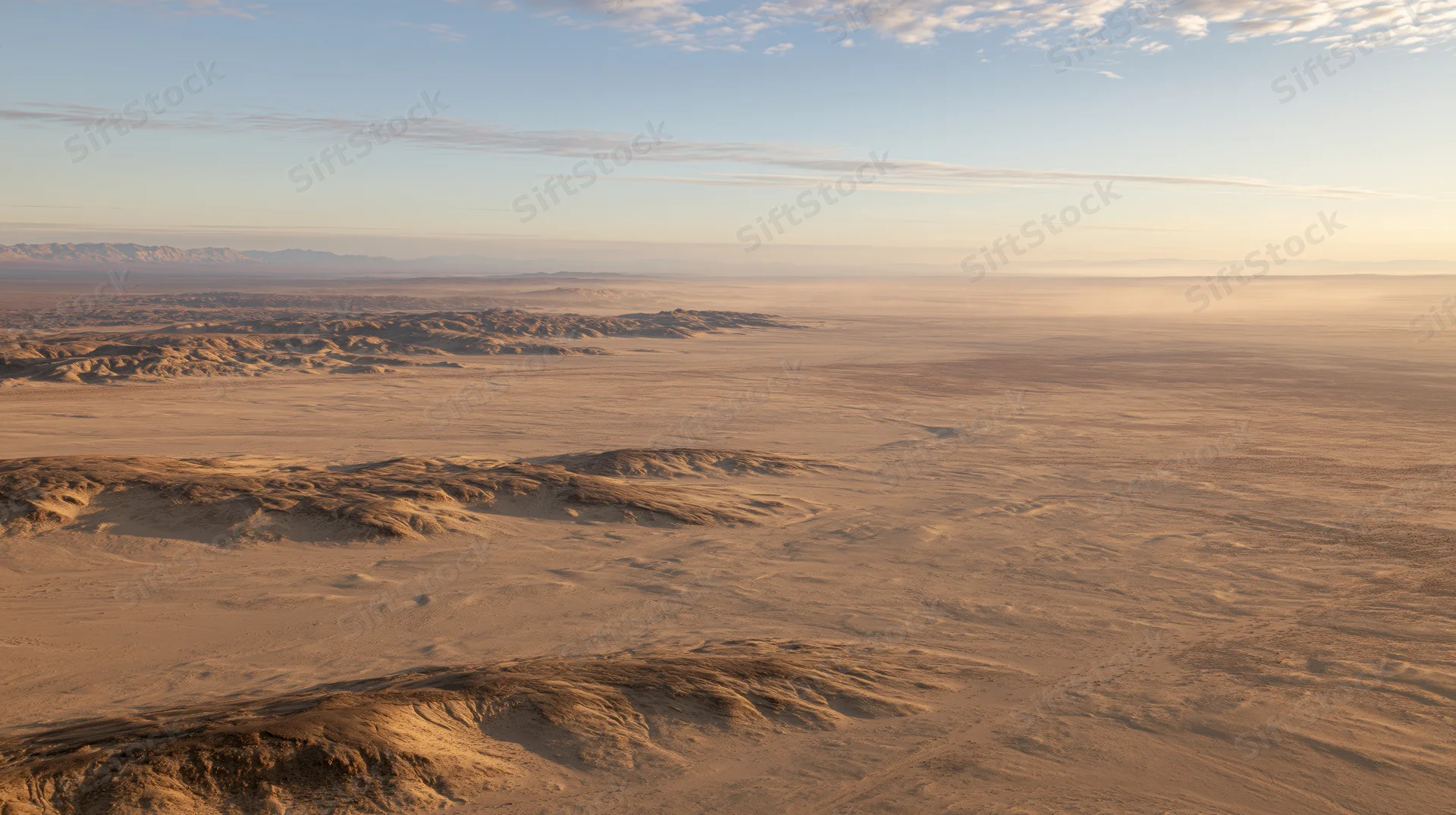 Aerial view of vast arid desert landscape stretching to the horizon under a clear sky