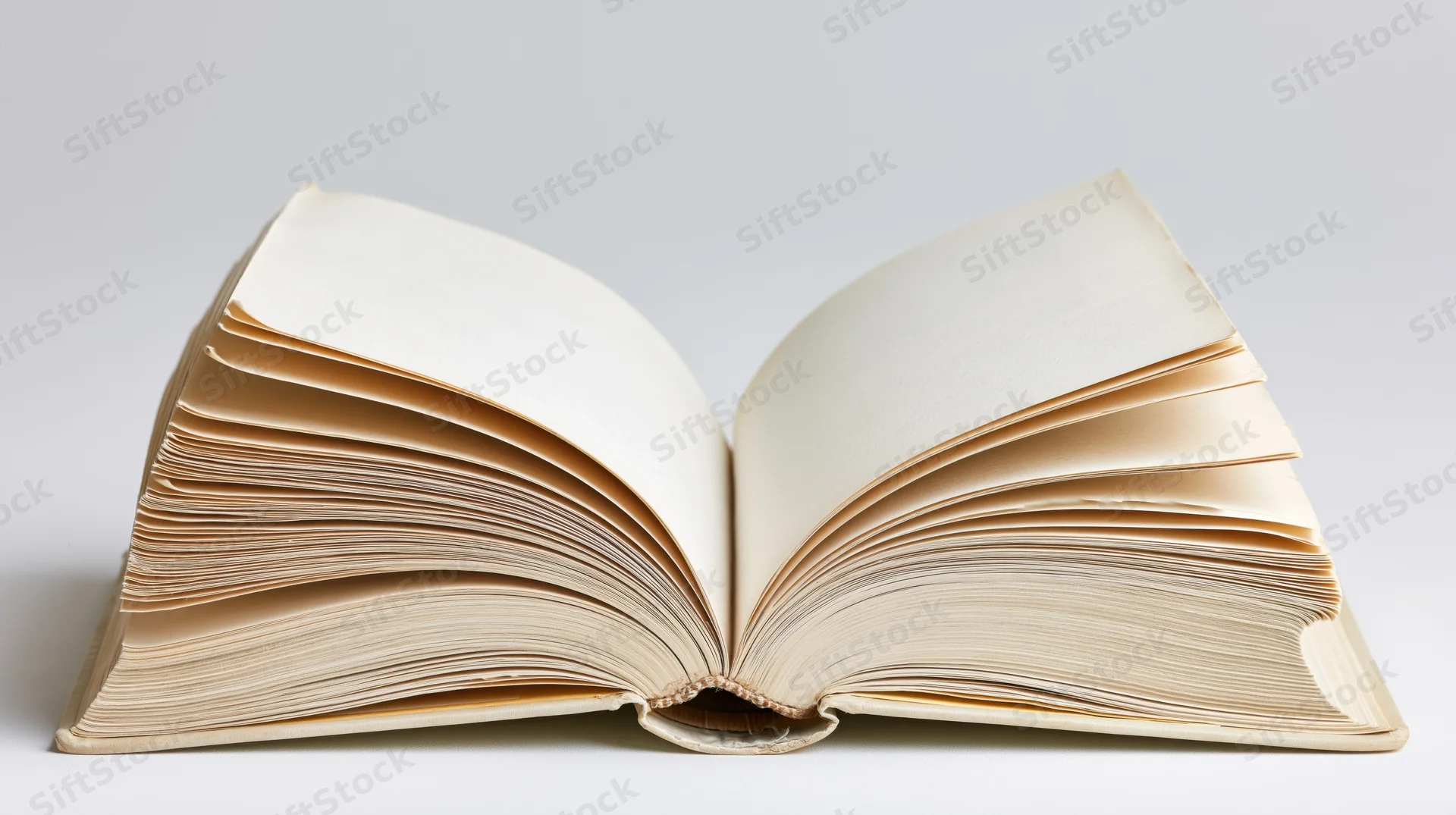 Open hardcover book with pages fanned out on white background