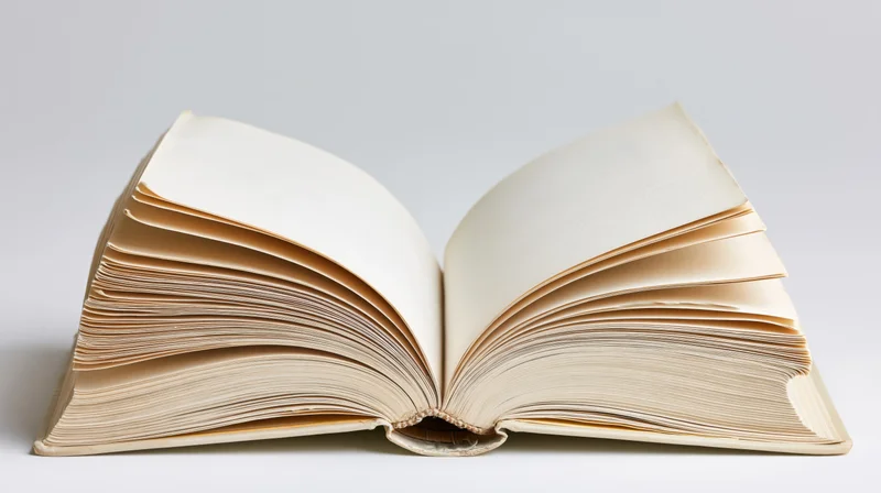 Open hardcover book with pages fanned out on white background