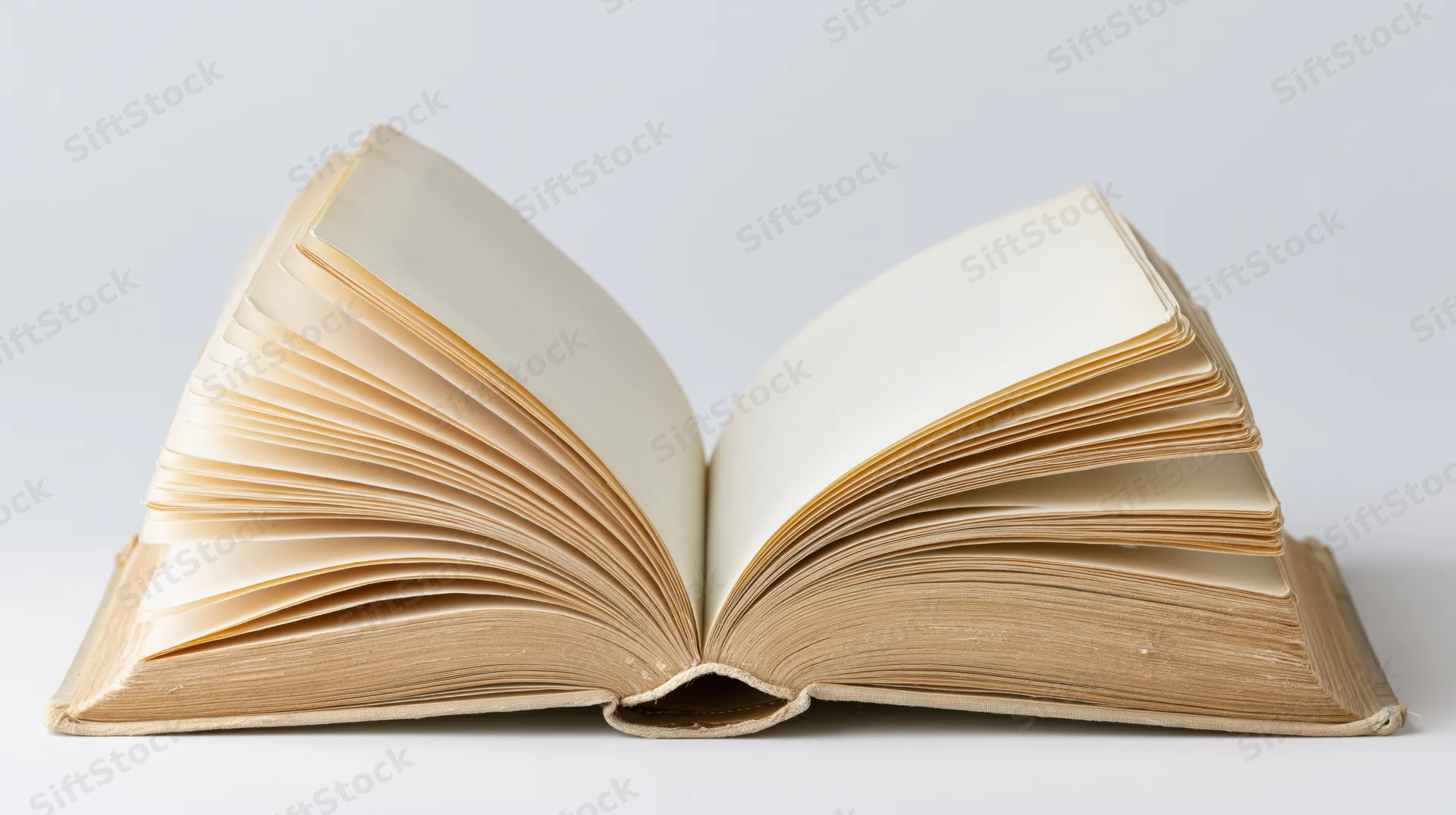 Open hardcover book with pages fanned out on white background