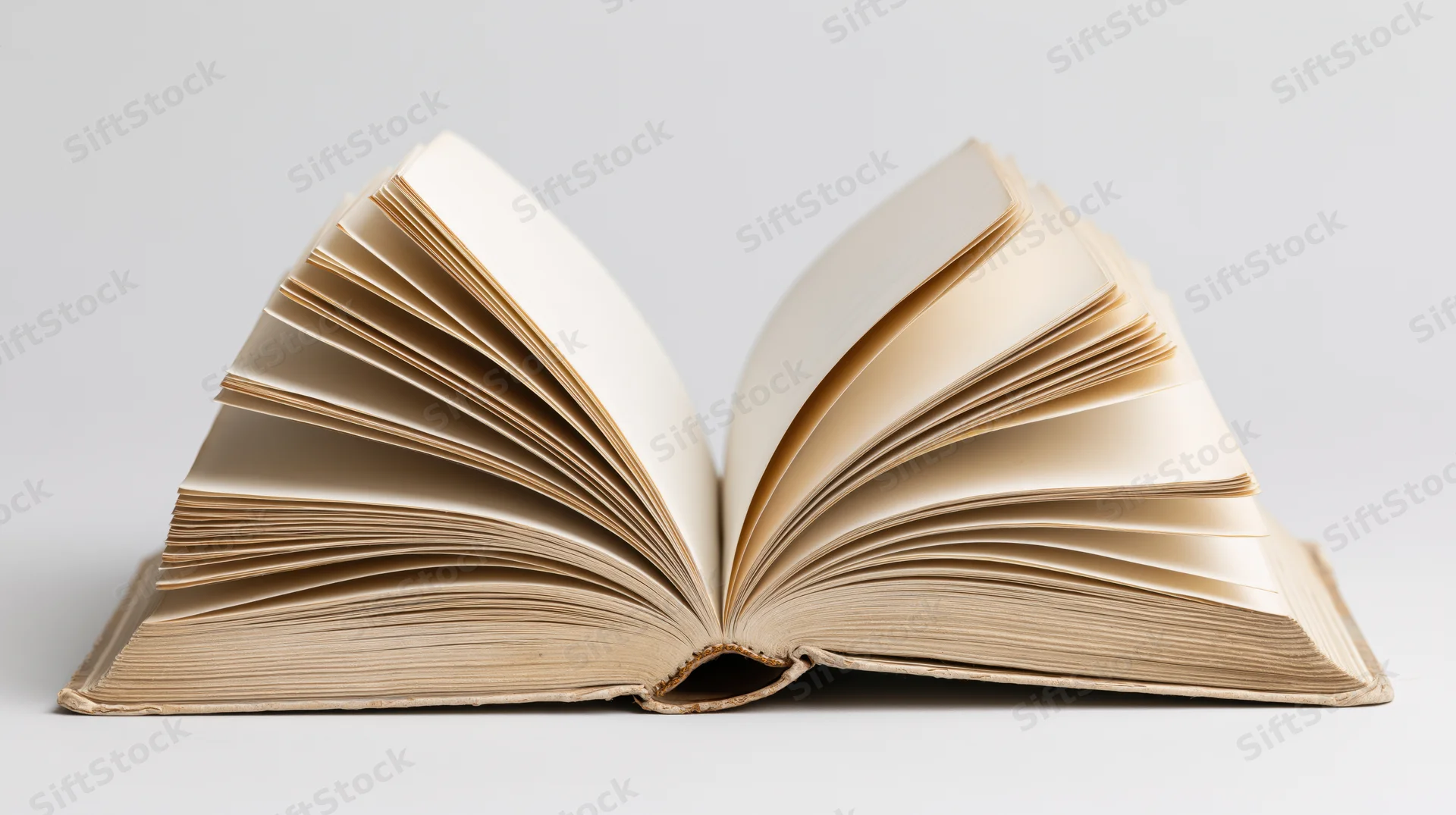 Open hardcover book with pages fanned out on white background